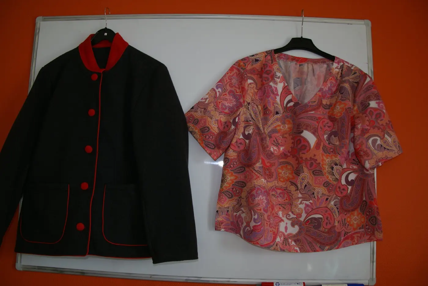 Une veste noire à col rouge et une blouse imprimée, cousues au cours de couture
